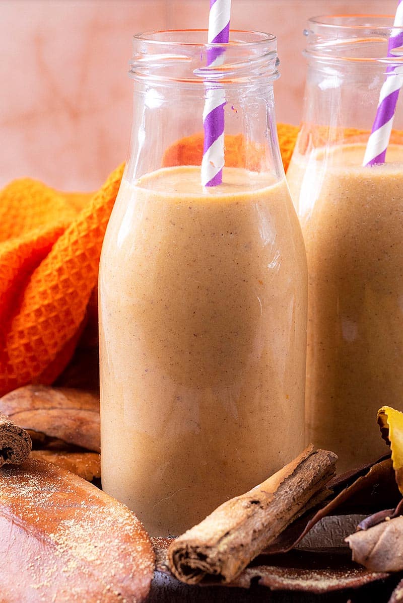 A glass bottle filled with pumpkin smoothie.